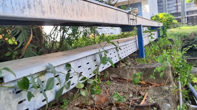 Outdoor Galvanized Perforated Cable Tray System Mounted on Concrete Wall with Blue Support Bracket