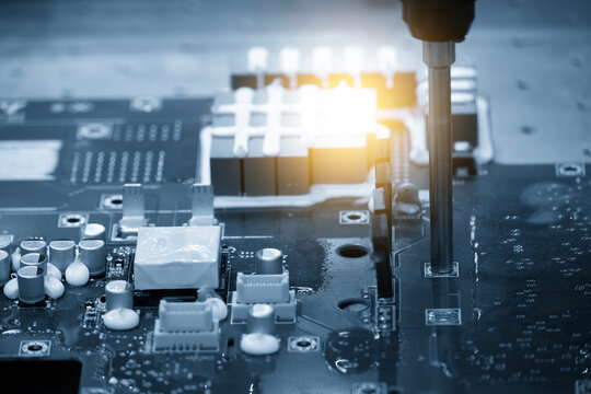 High-tech electronics circuit board assembly process executing by an automatic system in a blue tone scene.
