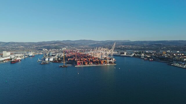 Aerial view of a busy shipping port with cargo containers and cranes handling maritime logistics for international freight transport.