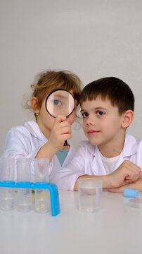 Laboratory examination of a child with test tubes, reagents and a microscope. Selective focus.