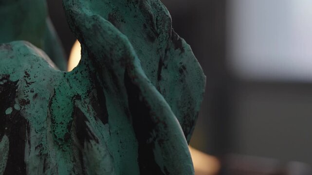 Process of applying patina to a metal sculpture in an outdoor workshop using a torch to create color and texture