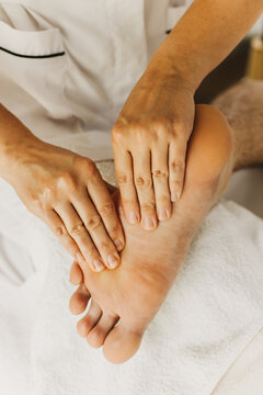 Close up of foot massage therapy session. Female massage therapist's hands.