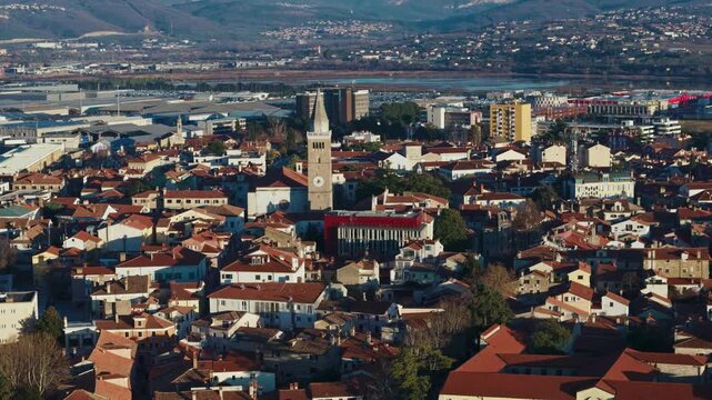 View of Kopers waterfront with boats in marina and city buildings along the shore under bright sky.
