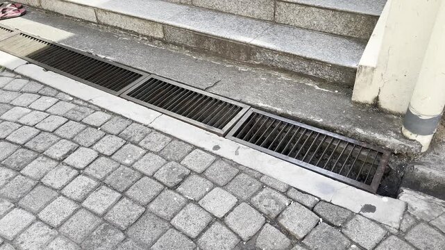 High Angle View of Steel Gutter Cover Grid on Pavement Road
