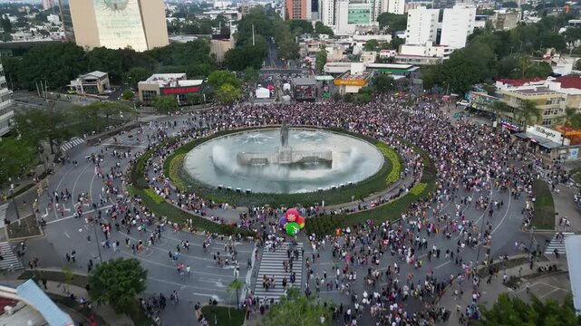 Guadalajara, Mexico - June 13 2026: Aerial drone video captures the vibrant Guadalajara Pride Parade 2026, a massive crowd gathered around the iconic Minerva roundabout