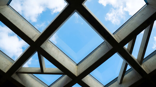 Concrete grid skylight framing blue sky and white clouds from below