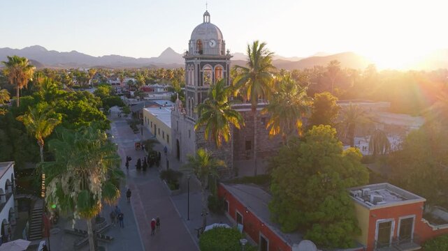 View the stunning sunset over Loreto Mission church in Baja California Sur Mexico showcasing the beauty of a desert oasis