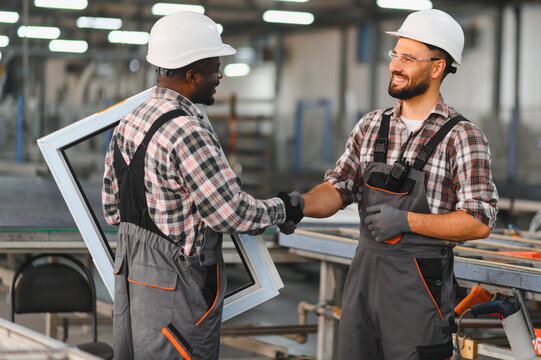 Factory workers shaking hands creating pvc window frames