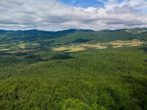 Aerial view of Bohunicky Rohac in Stiavnicke Vrchy with dense green forests and rolling hills under a cloudy sky in Bohunice, Nitra Region, Slovakia.