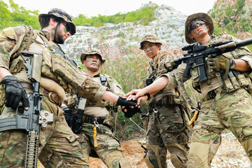 Fototapeta premium Special forces units, armed with war weapons are joining forces in unity surprise attack preparing mission to assault the enemy military. 