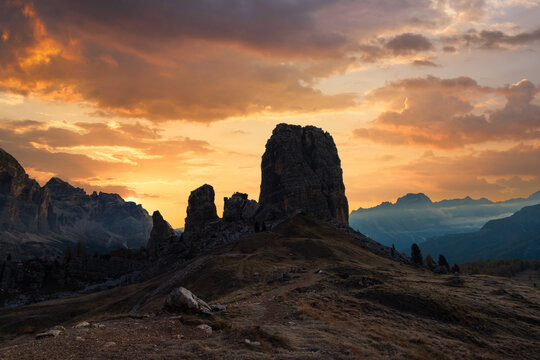 Cinque Torri silhouetted against a colorful sunset sky in the Dolomites. Dramatic evening light over an iconic alpine landscape in northern Italy