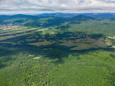 Aerial view of Bohunicky Rohac in Stiavnicke Vrchy featuring lush green forests and rolling hills under a cloudy sky in Bohunice, Nitra Region, Slovakia.