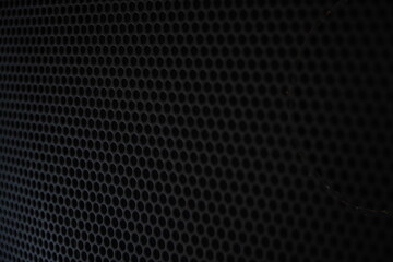 Naklejka premium Close-up of black metallic speaker grille texture background. Perforated metal mesh pattern with circular holes for audio equipment design. Abstract Background