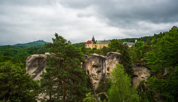 View from Marian Viewpoint in Hruba Skala, Bohemian Paradise (Cesky raj), overlooking Hruboskalsko rock city and Hruba Skala Castle under dramatic cloudy sunrise sky panorama.