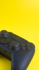 Vertical close up of blank black gamepad mockup on yellow background with negative space for gaming design.  © wibiwisnu