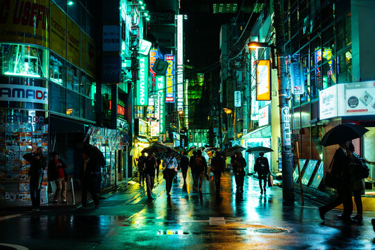 雨の秋葉原ジャンク通り・ツクモの緑のネオンが路面にきらめくサイバーパンクな夜