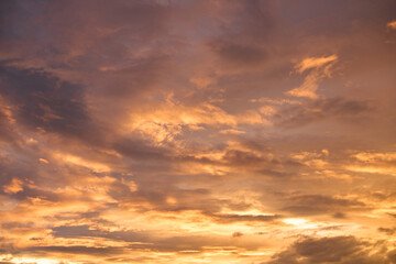 Fototapeta premium Dramatic golden sunset sky with purple clouds and warm sunlight background(