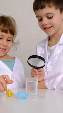 Laboratory examination of a child with test tubes, reagents and a microscope. Selective focus.