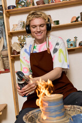 Young artisan shapes clay in a vibrant pottery workshop filled with creativity and joy © Bliss