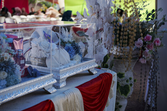 Traditional Indonesian Hantaran or Seserahan wedding gift boxes with clear acrylic covers displayed during a wedding ceremony, authentic bridal gift presentation