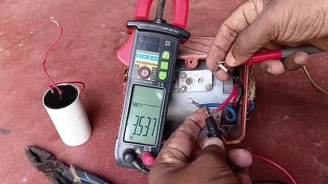 Measuring Stator Coil Resistance with Multimeter on Single Phase Induction Motor Running Winding Close Up
