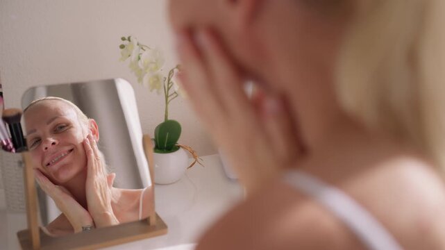Smiling woman admiring reflection in mirror, feeling confident and happy with appearance during peaceful self care moment at home.Self love, confidence , body positivity concept