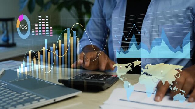 Businessman using calculator at desk with laptop papers and holographic digital charts overlay, showing finance analysis budgeting data tracking, Business finance analysis with calculator and digital 