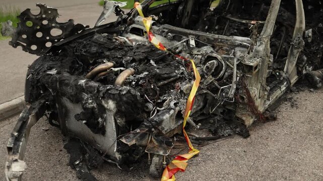severely burned car standing on the roadside after an engine related fire showing destruction risk and consequences of mechanical failure