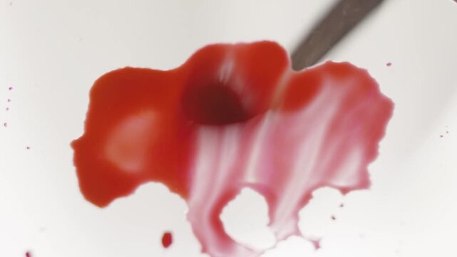 Close up of pink watercolour drawing paints on paper. Artist draws with a brush, liquid analog effects for background with copy space for text in center. 