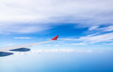 Fototapeta premium Wing of an airplane flying above the clouds