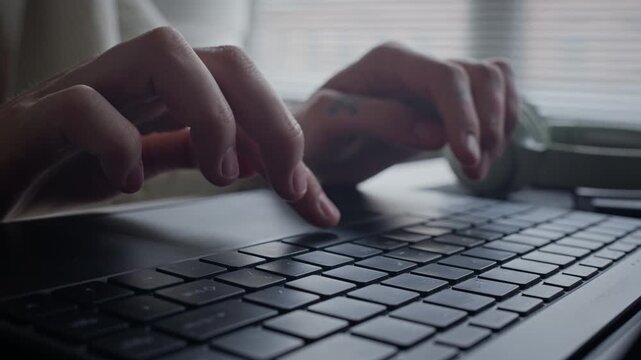Close up shot of Caucasian young adult programmer typing on laptop keyboard, developing software, writing code in office. For commercial videos about programming, artificial intelligence, remote work