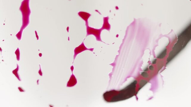 Close up of pink watercolour drawing paints on paper. Artist draws with a brush, liquid analog effects for background with copy space for text in center. 