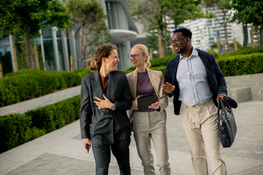 Group of colleagues walking together in a modern outdoor setting during the day