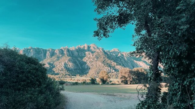 V&iacute;deo de paisaje natural con Montserrat al fondo, agua tranquila, bosque y luz clara de d&iacute;a.