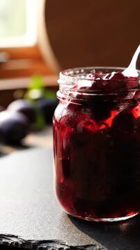 Jar of berry jam on rustic wood with soft blurred background