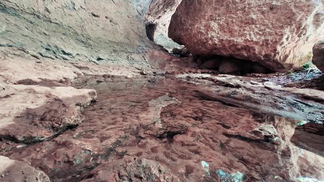 Superficie rocosa erosionada bajo un gran bloque de piedra en un entorno geol&oacute;gico natural &mdash; v&iacute;deo 4K