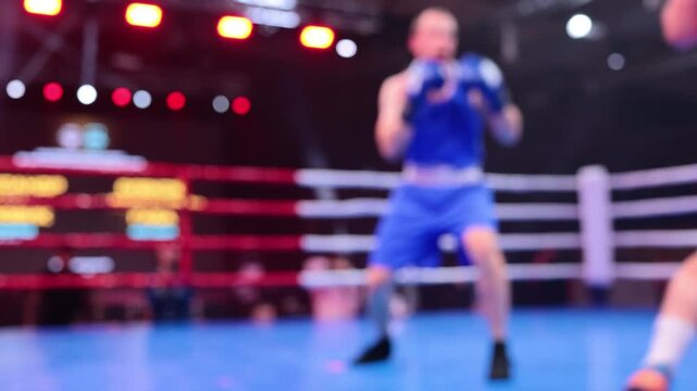 Blurred motion of two boxers exchanging punches in ring during boxing competition
