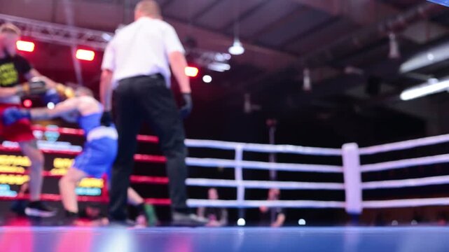 Blurred motion of two boxers exchanging punches in ring during boxing competition