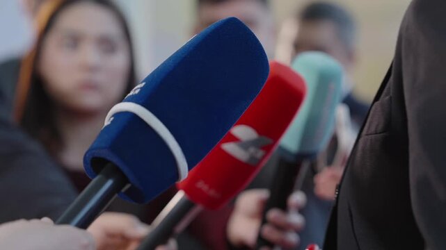 Close up of news microphones pointed toward speaker during press briefing, representing journalism, media coverage, public relations, interviews, information exchange, highlighting press conference