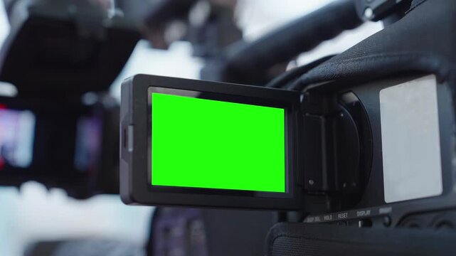 Close up professional video camera with chroma key green screen mockup on flip out display. Chroma Key Green Screen provides isolated screen area for content replacement, editing, post production