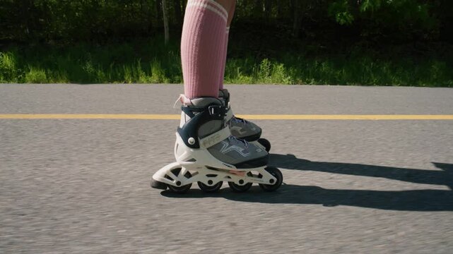 Wheels glide smoothly along a sunny path as legs twinkle in vibrant pink socks. Laughter fills the air, echoing through the trees as skaters enjoy the moment.