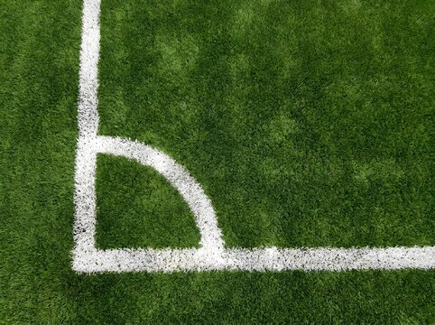 Overhead view of a painted white chalk corner on a green soccer field