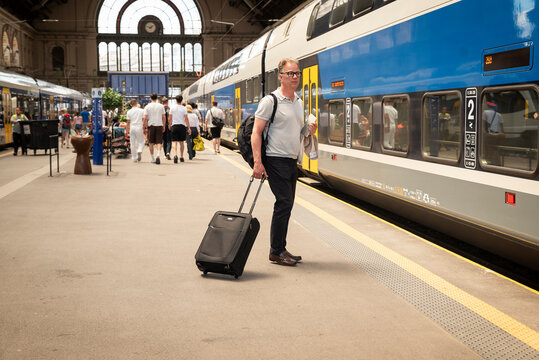 Mature businessman walking with luggage at railway station during business travel