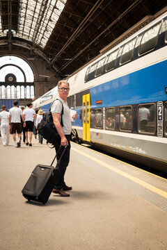 Mature businessman walking with luggage at railway station during business travel