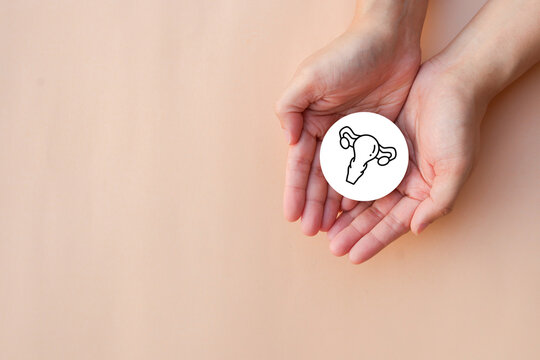 close up top view on woman hand with uterus symbol on beige background represent about uetrus health checkup and lifestyle for health and wellness concept