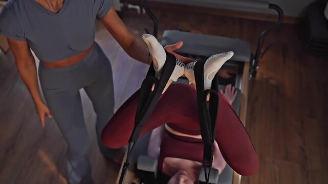A detailed closeup of a foot work and core exercise on a Balanced Body Reformer machine illuminated by sunlight