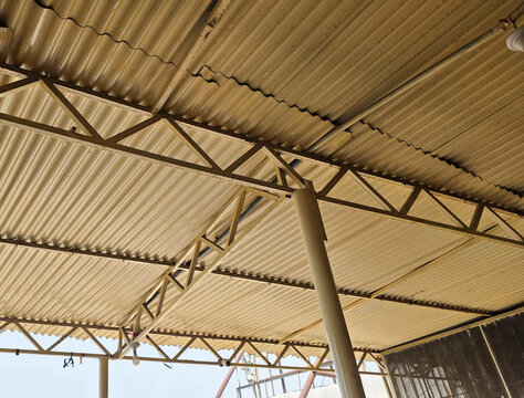 Close-up of corrugated metal roof structure with support beams