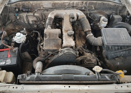 Dirty car engine compartment with exposed components