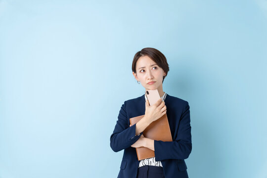 ビジネス　考える女性　ブルーバック