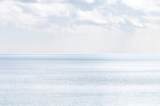 White and blue horizontal gradient abstract as a background which is the diffused sky with some clouds with horizon changing into the blue water of the Oresund sound between Denmark and Sweden